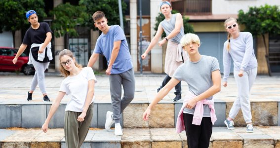 Jugendliche tanzen im Freien eine Choreografie 