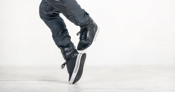 Tanzende Männerfüße in schwarzen Sneakers