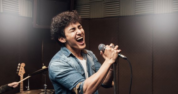 Ein Mann singt mit Leidenschaft in ein Mikrofon