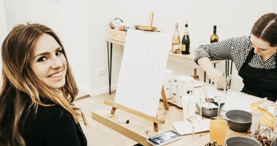 Frau lächelt beim Kunstkurs in die Kamera