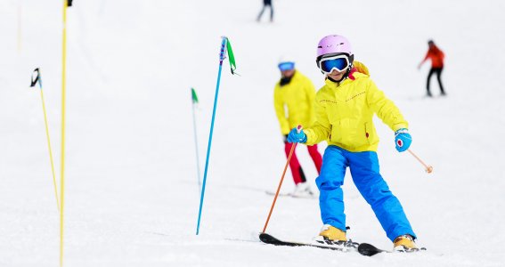 Junge fährt Slalom auf der Skipiste 