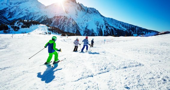 Gruppe von Kindern fährt die Skipiste herunter