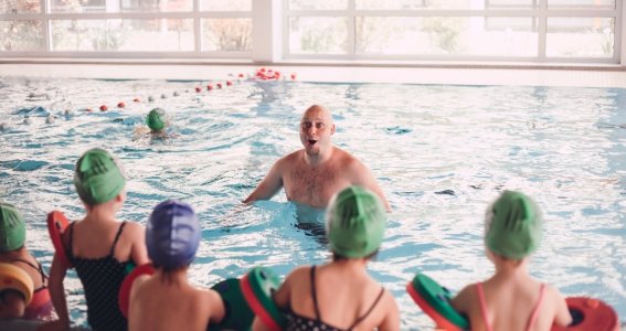 Schwimmlehrer wartet auf die Kinder im Wasser