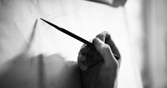 Hand zeichnet die ersten Linien auf ein Papier
