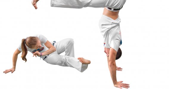 Ein junger Mann und eine junge Frau in Capoeira-Pose