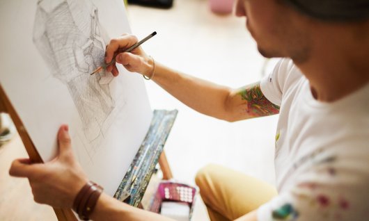 Mann zeichnet auf Staffelei