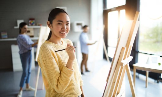 Jugendliche malen im Atelier auf Staffeleien