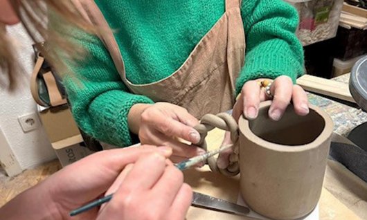 2 Frauen, die eine Tasse aus Keramik herstellen