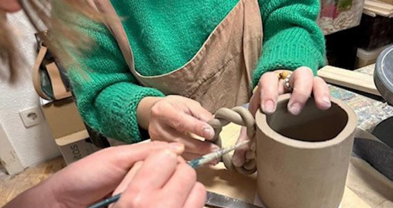 2 Frauen, die eine Tasse aus Keramik herstellen