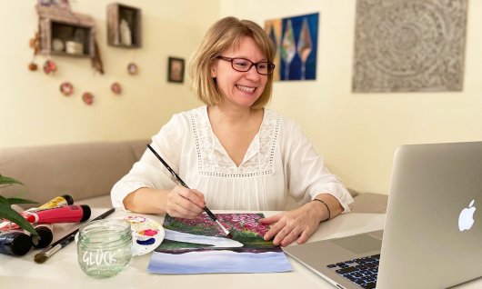 Frau nimmt an einem Online Malkurs teil.