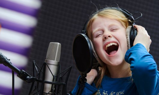 Mädchen singt ins Mikrofon