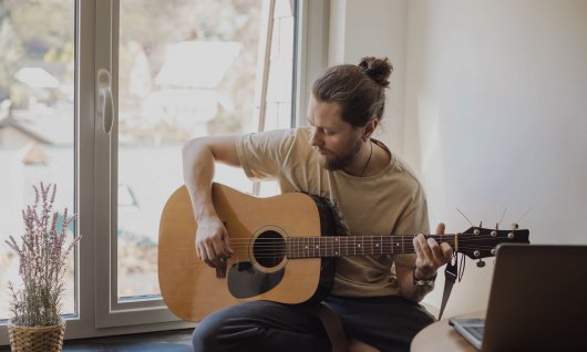 Mann spielt Gitarre
