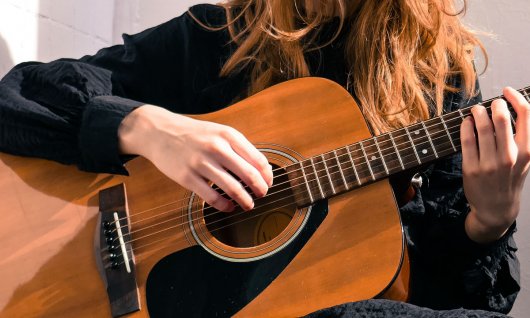 Mädchen spielt auf einer Gitarre