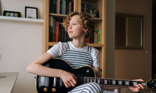 Kind spielt auf der Gitarre