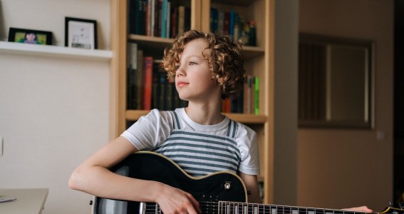 Kind spielt auf der Gitarre