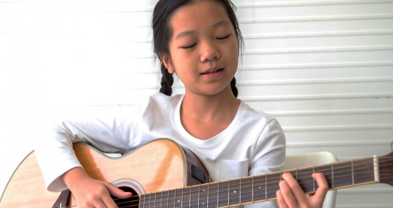 Kind spielt Gitarre
