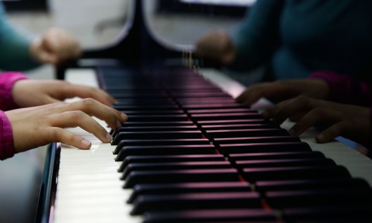 Kinderhände auf Klaviertasten