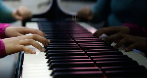 Kinderhände auf Klaviertasten