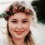 Ramona Kohout von Mona's Flower Marrow Eine junge, lächelnde Frau mit einem Haarkranz aus Blumen