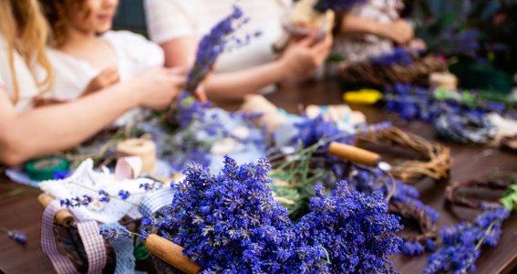 Ein Mädchen bindet unterschiedliche Trockenblumen zusammen