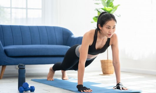 Frau ist in der Plank-Position.