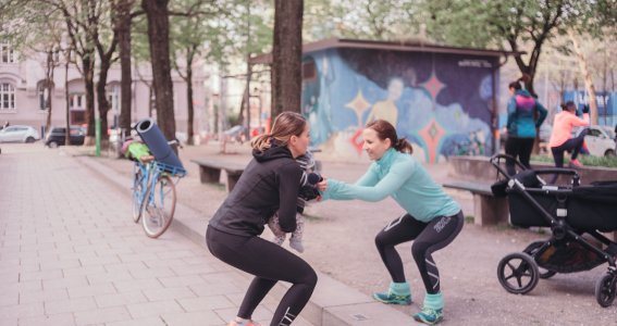 Mama mit Baby macht draußen Sport