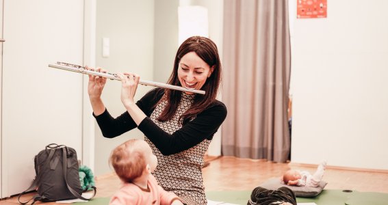Musiklehrerin spielt Querflöte für die Babys