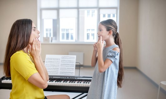 Mädchen bekommt Gesangsunterricht