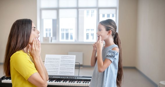 Mädchen bekommt Gesangsunterricht