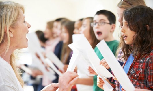 Kinder singen mit Notenblatt