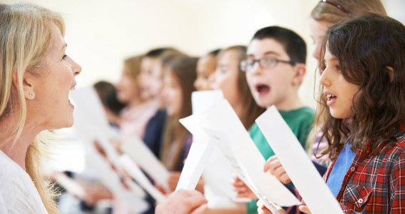 Kinder singen mit Notenblatt
