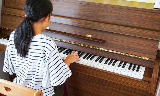 Mädchen spielt Klavier.