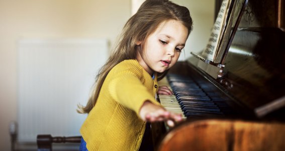 Kleines Mädchen spielt Klavier.