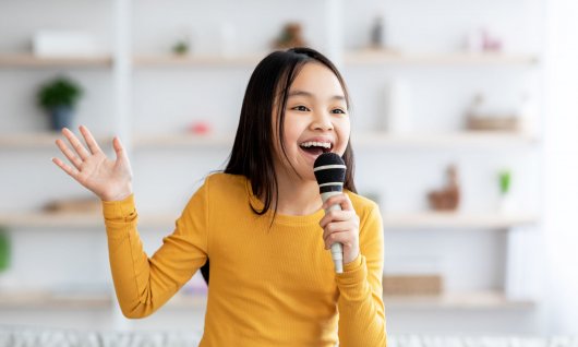 Mädchen singt zuhause.