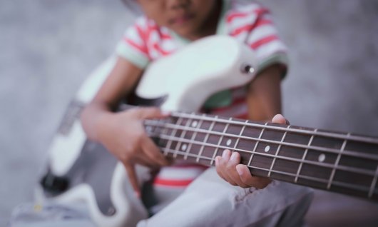 Bass spielen für Kinder Mädchen spielt auf dem Bass