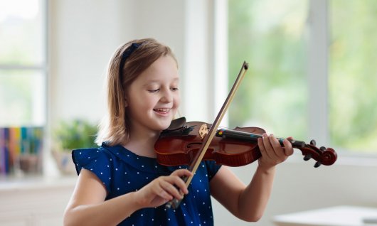 Online Geige lernen für Kinder Mädchen spielt lachend Geige