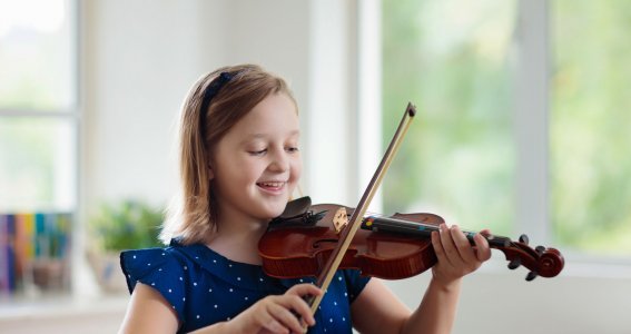 Mädchen spielt lachend Geige