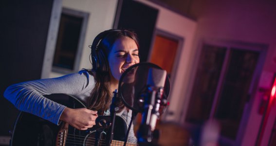 Jugendliche singt und spielt Gitarre 