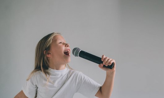 Mädchen singt in ein Mikrofon