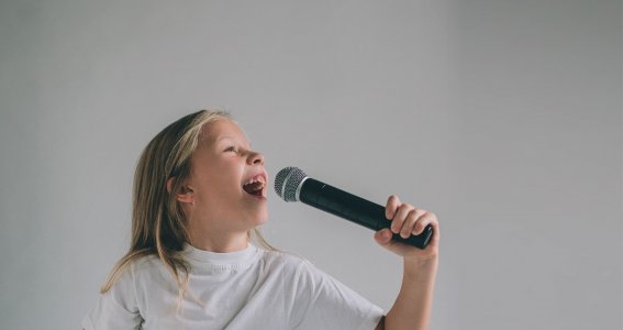 Mädchen singt in ein Mikrofon