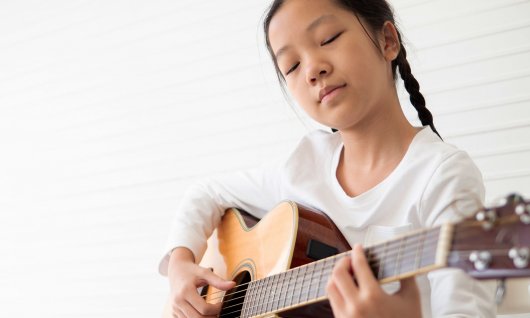 Mädchen spielt auf die Gitarre
