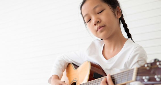 Mädchen spielt auf die Gitarre