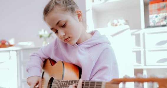 Mädchen schaut auf eine Gitarre