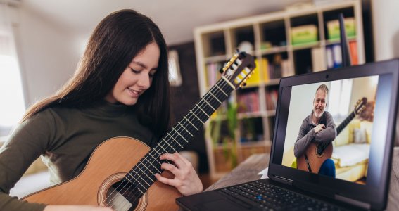 Jugendliche spielt Gitarre im Onlinekurs