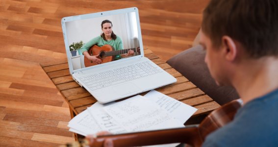 Person mit Gitarre auf dem Laptopbildschirm