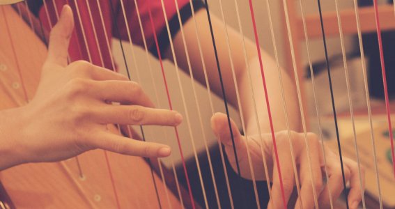 Hände an einer Harfe