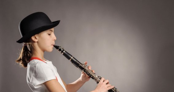 Mädchen mit Hut spielt Klarinette