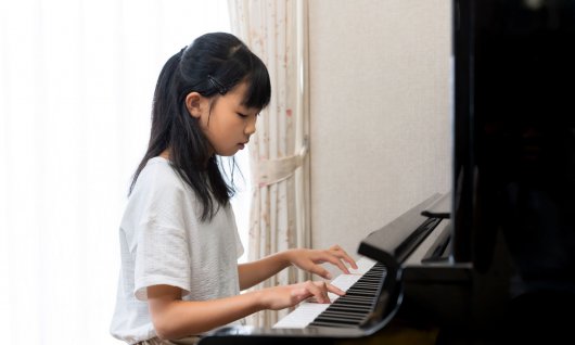 Klavierunterricht für Kinder in München Giesing Mädchen drückt auf die Tastatur eines Klavieres