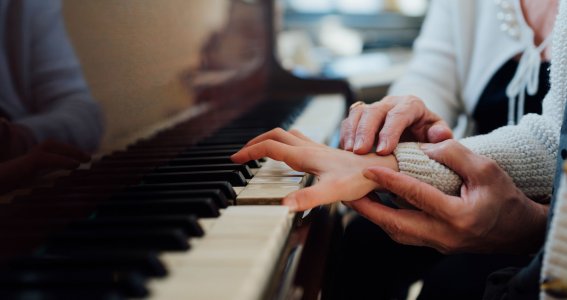 Kinderhände werden an Tastatur geführt