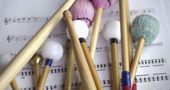 Trommelsticks liegen auf Noten